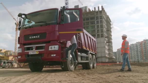 Moskou, Rusland - juni, 2018: Architecten schudden hand op de bouwplaats. Scène. Kamaz stuurprogramma schudt de hand met de ingenieur op de bouwplaats — Stockvideo