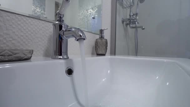 Open chrome kraan wastafel. Er stroomt water uit de kraan in de moderne badkamer — Stockvideo