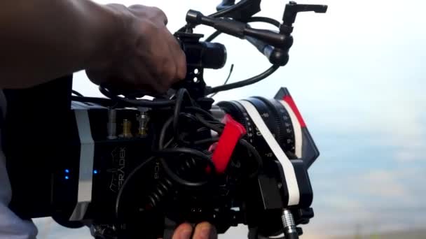 Hombre sosteniendo una cámara filmando una película en el bosque. Cámara costosa para la película en el bosque — Vídeos de Stock