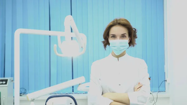 Mujer dentista se encuentra con el cliente sonriendo. Medios. Mujer dentista en bata blanca da la bienvenida a un nuevo cliente en el consultorio dental. Concepto dental —  Fotos de Stock