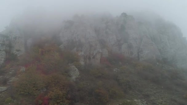 Крупним планом величезні скелі в тумані. Постріл. Осінній пейзаж — стокове відео