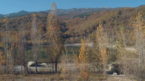 Krásný výhled na jezero poblíž hory a stromy. Střela. Úžasný podzimní krajina — Stock video