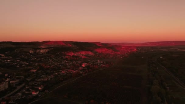 Flygfoto över fantastiska ljusa röda solnedgången över staden. Skott. Vackert landskap — Stockvideo