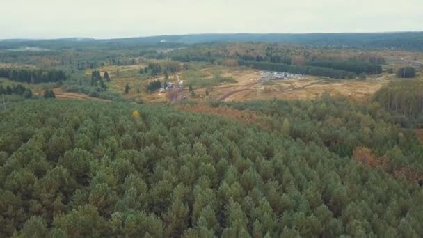 Camino de campo húmedo y sucio cerca del bosque con coches y camiones. Clip. Vista aérea — Vídeo de stock