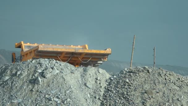 重ダンプ トラックは、鉱石をアンロードするのには終了し、採石場の葉します。バックからの眺め. — ストック動画
