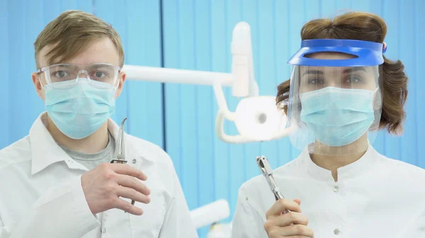 Dentisti e dentisti mascherati e mascherati. I media. Partner dentisti in uniforme protettiva sterile con attrezzatura pronta a mettersi al lavoro — Foto Stock