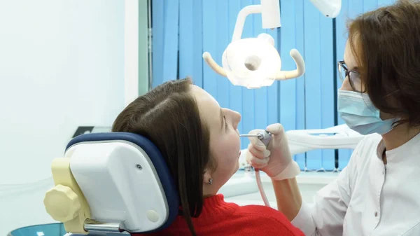 Vrouw tandarts in gesprek met de patiënt. Media. Tandarts vrouw consulteert patiënt over behandeling voordat de werkzaamheden aanvangen — Stockfoto