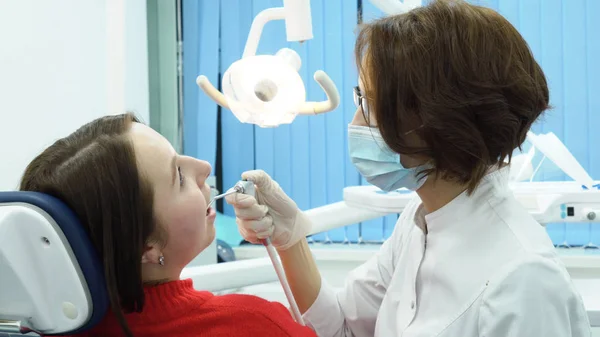 Mujer dentista hablando con paciente. Medios. Mujer dentista consulta a paciente sobre tratamiento antes de comenzar el trabajo —  Fotos de Stock