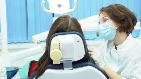 Dentista trabajando con asistente. Medios. El dentista después de trabajar con una herramienta se la da al asistente durante el procedimiento —  Fotos de Stock
