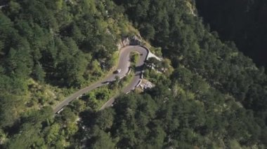 Yaz aylarında muhteşem gür ormanlık dağ yamacında dalgalı yol sürüş joyride üzerinde uçan yukarıda motosiklet ve bir araba. Hisse senedi. Dağ yolu, havadan görünümü
