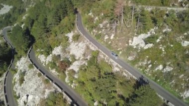 Serpantinli yol yüksek Dağları'nın hava manzaralı dağ uçurumun kenarında. Hisse senedi. Havadan görünümü manzara serpantin yol dağlar arka plan üzerinde yaz güneşli bir günde sarma