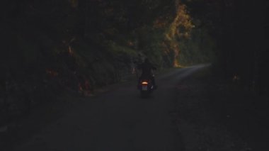 Dikiz bir adam bir motosiklet binme. Hisse senedi. Adam bir motosiklet orman asfalt yolda sürme