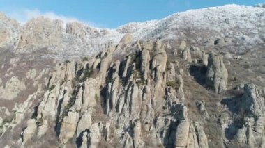 Kaya oluşumu mavi berrak gökyüzü ve donmuş çalılar tarafından kaplı dağın tepesine karşı hava görünümünü. Vurdu. Kayalara tırmanma.