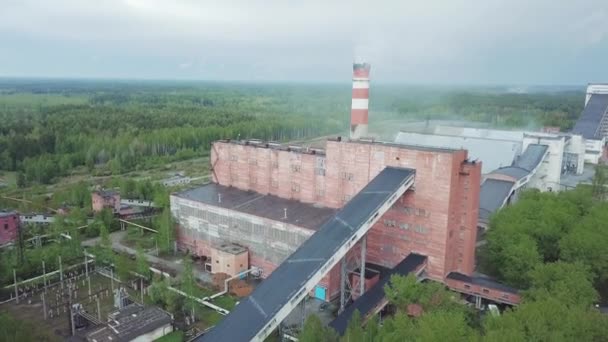 Gammal röd industriella fabriksbyggnad med höga skorstenen mot grå regnig himmel. Flygfoto. — Stockvideo