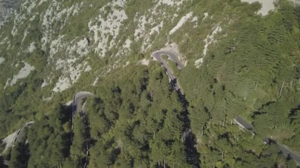 Serpentiner vägen på sidan av berget klippan med Flygfoto över de höga bergen. Lager. Aerial View landskap serpentinväg slingrande på bergen bakgrunden i soliga sommardag — Stockvideo