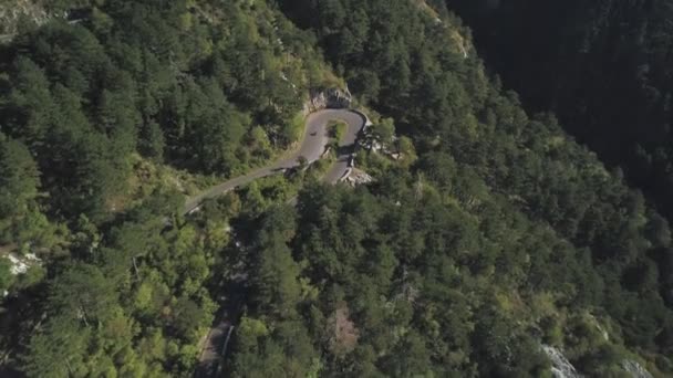 Volare sopra la moto e una macchina in joyride guida attraverso la strada ondulata sulla splendida lussureggiante pendio boschivo di montagna in estate. Azioni. Strada di montagna, vista aerea — Video Stock