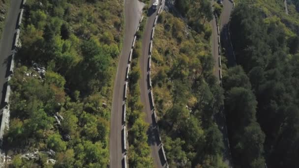 Luchtfoto schot over beroemde serpentine bergweg. Voorraad. Serpentines wegnaar verkeer aan de kant van de berg klif — Stockvideo