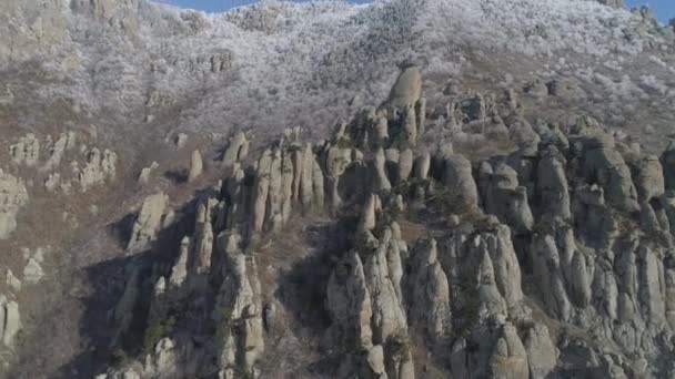 Obrovské a bizarní tvarované skalní útvar na horském svahu s keře a malé stromy. Střela. Letecký pohled. — Stock video
