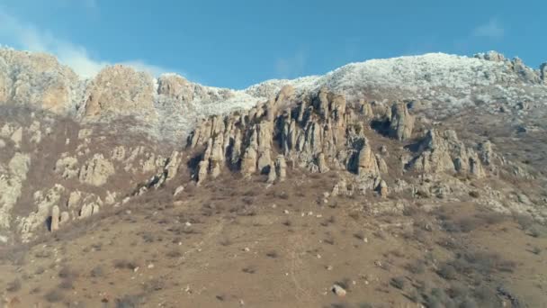 Majestátní skalní útvar na zelené stráně vztahuje keřů na jasný slunečný den proti modré obloze jasné. Střela. Letecký pohled. — Stock video