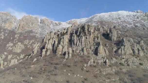 Vue aérienne de la formation rocheuse contre le ciel bleu clair et le sommet de la montagne recouvert d'arbustes gelés. Fusillade. Escalader les rochers . — Video