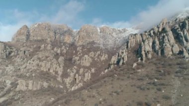 Sarp dağ eğim ile büyük kayalar, donmuş çalılar güzel bulutlu mavi gökyüzü karşı tarafından güneşli gün kapalı. Vurdu. Harika dağ manzaralı.