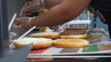 Kızarmış pirzola, peyniri ve sebze, seçici odak ile klasik hamburger yemek Mcdonald işçilerin yakın çekim. Çerçeve. Lezzetli hamburger hazırlama.