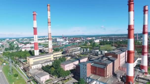 Flygfoto av industrianläggningar med röd och vit randig skorstenar nära vägen. Footage. Industriella zonen från ovan — Stockvideo