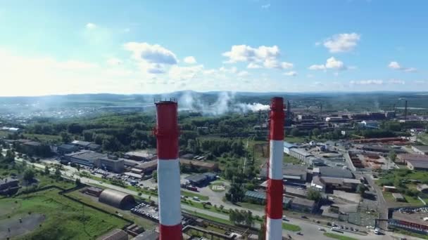 Närbild av industrianläggningar med röd och vit randig skorstenar nära vägen. Footage. Industriella zonen från ovan — Stockvideo