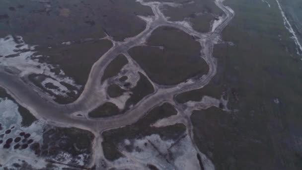 Вид на большую и широкую реку, покрытую льдом и снегом. Выстрел. Прекрасный зимний пейзаж сверху — стоковое видео