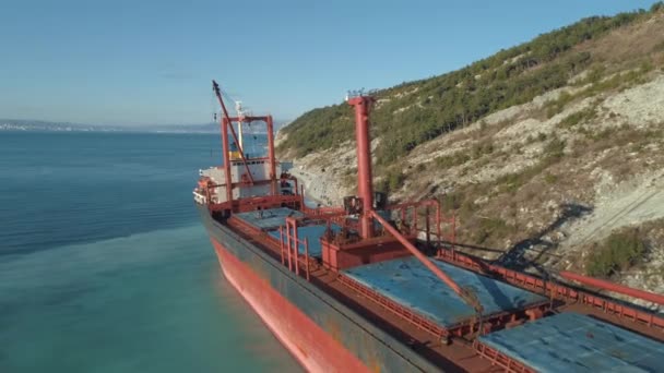 Primo piano di una grande nave da carico rossa in piedi in acque tranquille vicino alla costa. Gli hanno sparato. Paesaggi marittimi — Video Stock