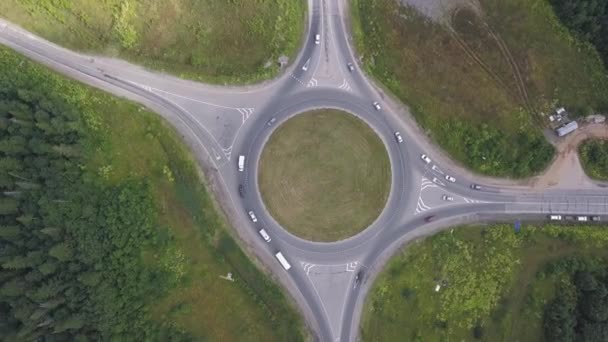 Luchtfoto van rotonde cirkel met bewegende auto's in de buurt van het bos. Clip. Land spoor — Stockvideo