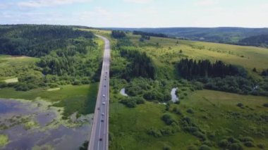 Havadan görünümü bir bataklık su ve valley crossing arabalar hareket ile meşgul köprü yol. Küçük. Taşıma arabaları.
