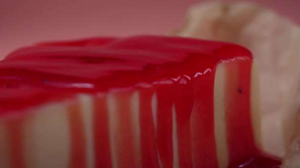 Close-up of homemade cheesecake, which is covered by berry jam on a pink background. Frame. Delicious dessert — Stock Video