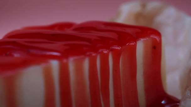 Close-up of homemade cheesecake, which is covered by berry jam on a pink background. Frame. Delicious dessert — Stock Video