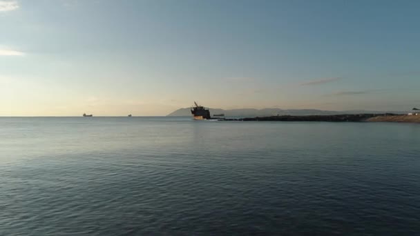 Blick auf ein rostiges Wrackschiff auf einer Untiefe im Meer gegen den Sonnenuntergang. Schuss. altes Seeschiff — Stockvideo