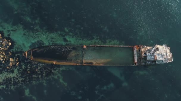 Вид с воздуха на ржавый затонувший корабль, застрявший на скалистом отмеле. Выстрел. Старое морское судно — стоковое видео