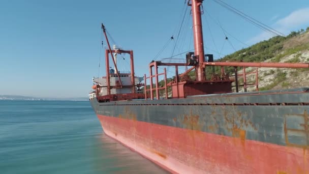 在岸边附近的码头上的红色大型货轮特写镜头。拍摄。海上运输 — 图库视频影像