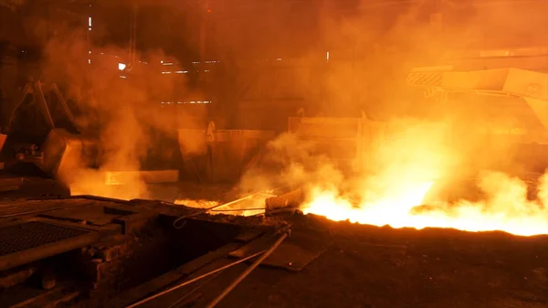 Negozio caldo presso la fabbrica metallurgica con acciaio fuso nello scivolo. Filmati delle scorte. Lavori metallurgici, processo industriale, produzione di ferro . — Foto Stock