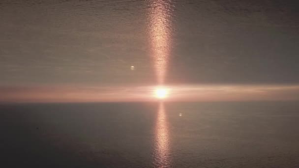 Prachtige zonsondergang in de zee met een spiegeleffect horizon. De avondzon op de horizon met blikken, aanvang thema. — Stockvideo