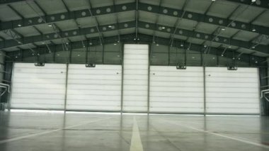 Büyük modern uçak hangar büyük güneşli yaz günü kapıda ile. Uçak hangar kapısı