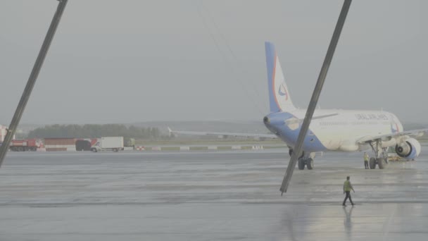 Ekaterimburgo, Rusia - agosto de 2017: Avión de pasajeros frente al hangar, preparándose para el servicio de un avión de pasajeros. El avión en el hangar, detrás de todo el avión y la pasarela . — Vídeo de stock