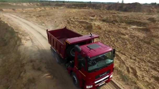 Dump truck rijden op het platteland. Scène. Bovenaanzicht van vrachtwagen rijden op steengroeve weg in platteland op de achtergrond van uitgegraven kuilen en bos op horizon — Stockvideo