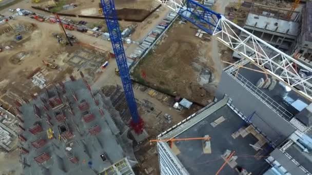 Blick von oben auf Baustelle mit Kran. Szene. Kran steht über Hausdächern auf Baustelle, stehende Autos auf der Straße. städtischer Bau von Wohngebäuden — Stockvideo