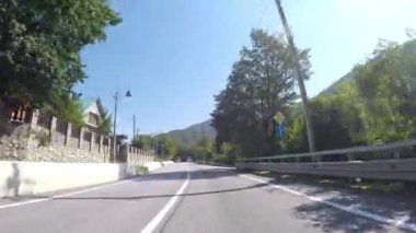 Orman ile dağ asfalt yolda araba sürmek. Sahne. Kırsal otoyol trafik ile dağlık alanda ve yeşil ve mavi gökyüzü ile güzel manzara