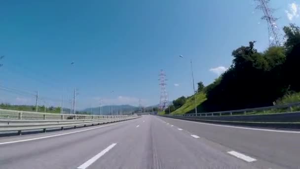 교외 고속도로에 자동차에서 보기. 장면입니다. 고속도로 입구에서 도시 지평선과 푸른 하늘에 아스팔트도로, 산의 아름 다운 전망 — 비디오