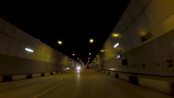 Paseos en coche en el túnel de asfalto. Escena. Hermoso paisaje urbano de nuevo túnel de carretera con tráfico a la luz de linternas amarillas — Vídeo de stock