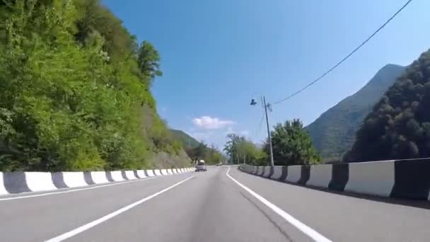 Bil rider på asfalt bergsväg med trafik. Scen. Mountain slingrande spår med biltrafik och vacker utsikt över berg-slutta med grönska på sommaren — Stockvideo