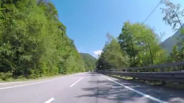 Promenades en voiture sur route de montagne asphaltée avec circulation. Scène. Montagne piste sinueuse avec circulation automobile et de belles vues sur la pente de montagne avec verdure en été — Video