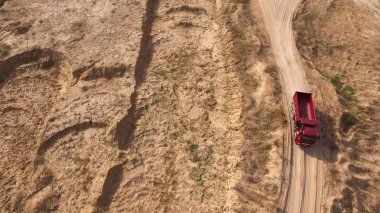 Üstten Görünüm kamyonun sürüş kırsal yolda. Sahne. Damperli kamyon ile yaz aylarında kuru sarı taş ocağı yolda gidiyor. Ağır makine inşaat ve taş ocağı yollarda