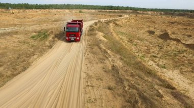 Damperli kamyon açık pit yolda. Sahne. Damperli kamyon ile orman ufukta kil yol ocağı kırsal üzerinde sürüş Üstten Görünüm